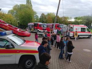 Fahrzeuge diverser Hilfsorganisationen auf dem Pausenhof